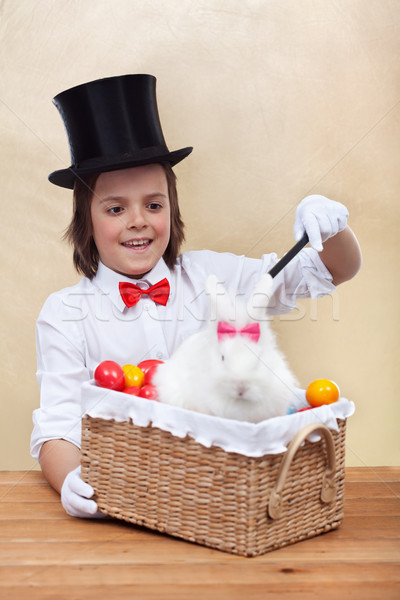Happy magician boy conjuring an easter rabbit and colorful eggs Stock photo © ilona75