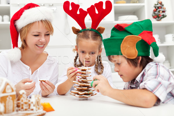 Happy family making a gingerbread cookie christmas tree Stock photo © ilona75