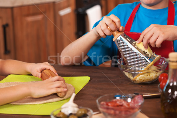 Kids preparing a pizza together - closeup on hands, shallow dept Stock photo © ilona75