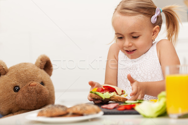 Little girl making a sandwich to her teddy bear Stock photo © ilona75