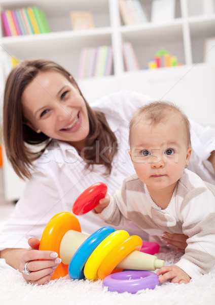 Stock photo: Wait - that is interesting - baby girl playing on the floor