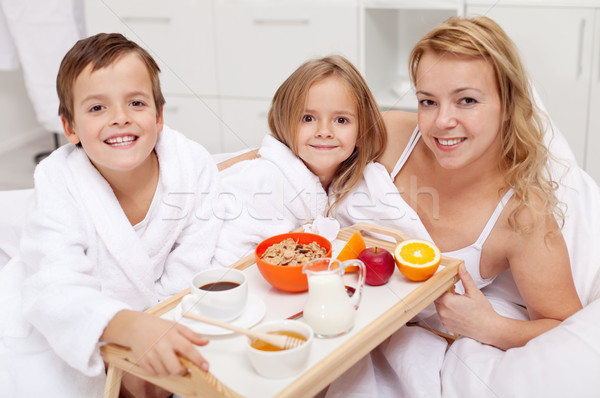Woman having breakfast in bed with the kids Stock photo © ilona75