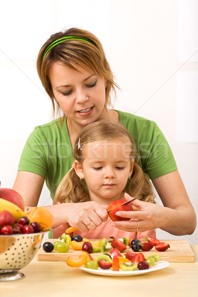 Stock photo: Woman and little girl slicing fruits