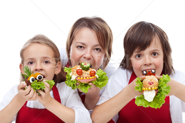 Woman and kids taking a bite from creative sandwiches Stock photo © ilona75