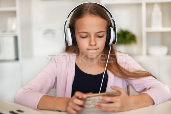Young girl listening to music on her phone and headset Stock photo © ilona75