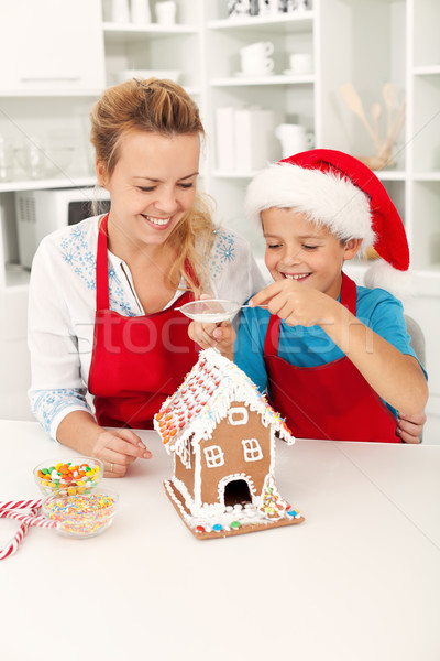 Final touches on the gingerbread house - people at christmas tim Stock photo © ilona75