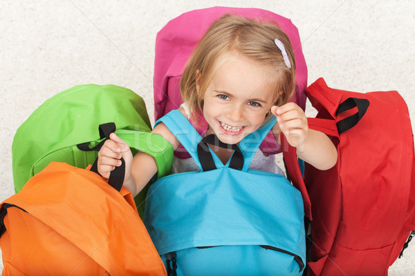 Happy preschooler girl choosing her school bag from a colorful s Stock photo © ilona75