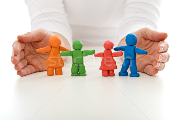 Clay people family protected by woman hands Stock photo © ilona75