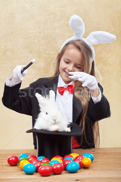 Happy magician girl conjuring up the easter bunny and eggs Stock photo © ilona75