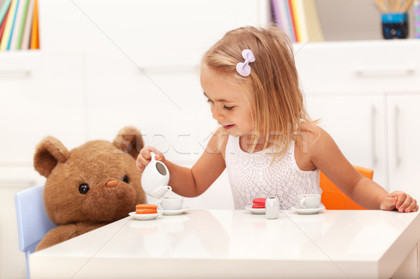 Little girl serving tea to her toy bear Stock photo © ilona75