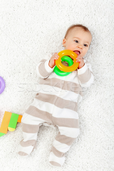 Baby girl playing on the floor chewing toys Stock photo © ilona75