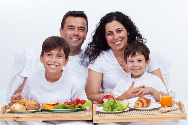 Happy family with two kids having breakfast in bed Stock photo © ilona75