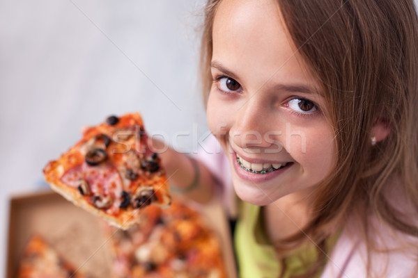 Young teenager girl with wide smile showing her favorite meal -  Stock photo © ilona75