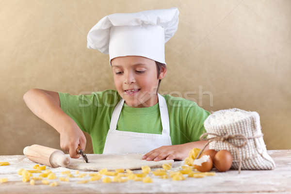 Little chef cutting the dough making pasta Stock photo © ilona75