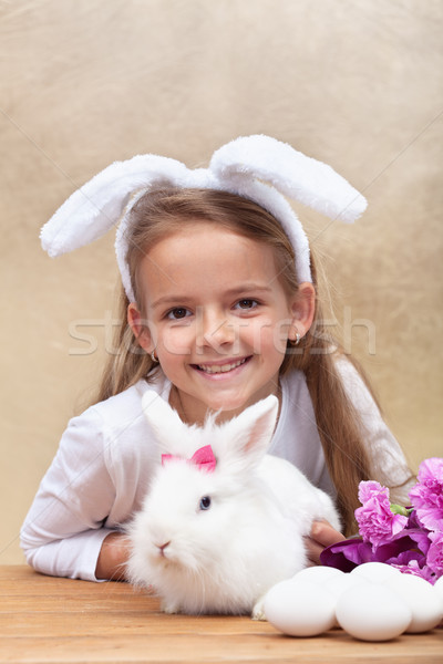 Happy little girl with bunny ears and her cute white rabbit Stock photo © ilona75