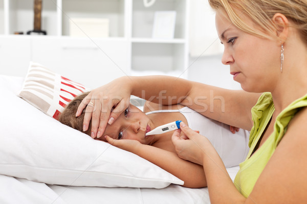 Sick kid with high fever and a worried mother Stock photo © ilona75