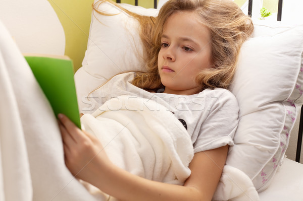 Young girl reading a book in bed, shallow depth Stock photo © ilona75