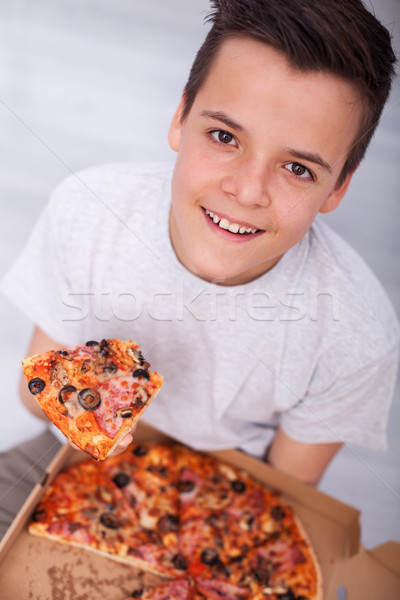 Young teenager boy sitting on the floor with a box of pizza - sm Stock photo © ilona75