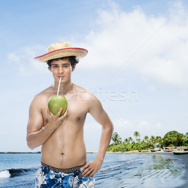 Człowiek pitnej mleko kokosowe plaży niebo wody Zdjęcia stock © imagedb