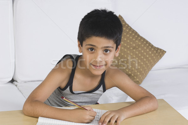 Portret chłopca posiedzenia sofa piśmie student Zdjęcia stock © imagedb