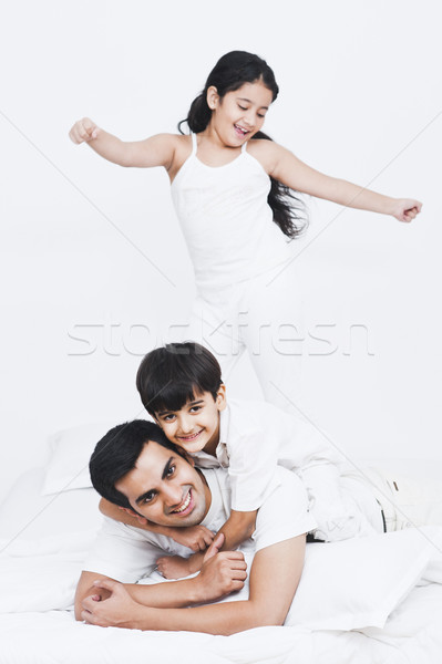 Father playing with their children on the bed Stock photo © imagedb