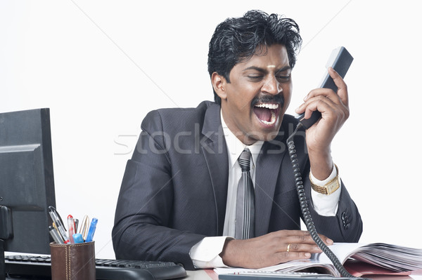 South Indian businessman working in an office and shouting Stock photo © imagedb
