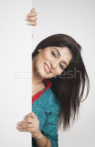 Femme derrière mur souriant porte amusement [[stock_photo]] © imagedb