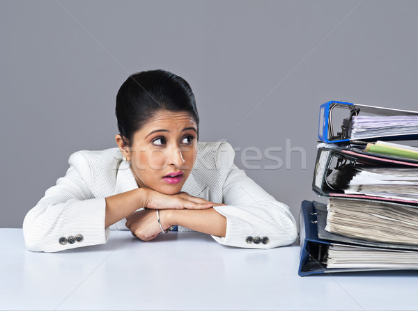 Businesswoman looking at piles of files in an office Stock photo © imagedb