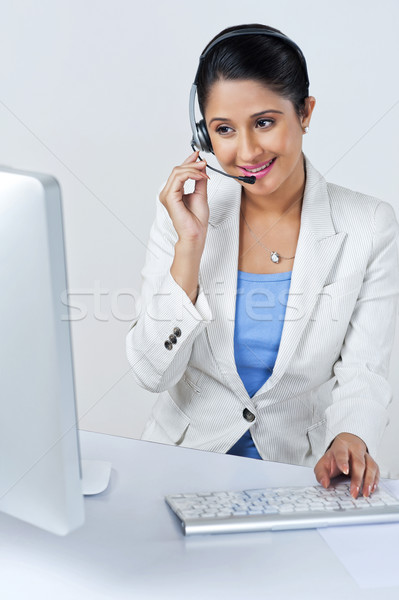Female customer service representative using a desktop pc Stock photo © imagedb