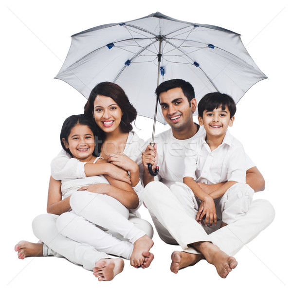 Portrait of a happy family sitting under an umbrella Stock photo © imagedb