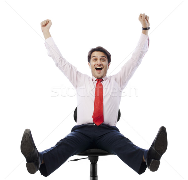 Businessman sitting on an office chair and looking excited Stock photo © imagedb