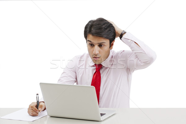 Businessman using a laptop and looking shocked Stock photo © imagedb