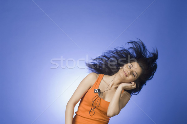 Młoda kobieta słuchania mp3 player niebieski kobieta muzyki Zdjęcia stock © imagedb