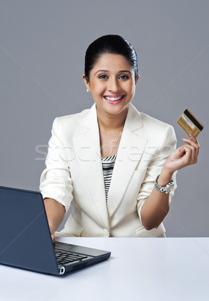 Businesswoman doing online shopping with a laptop and smiling Stock photo © imagedb