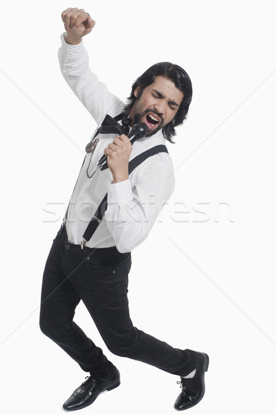 Singer holding a mike and singing Stock photo © imagedb