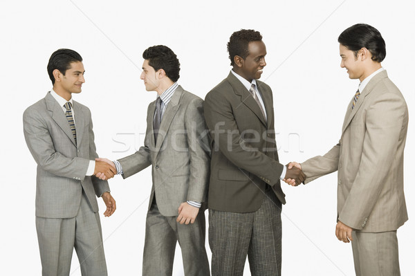 Vier Geschäftsleute Händeschütteln Geschäftsmann Handshake lächelnd Stock foto © imagedb