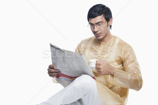 Bengali man reading a newspaper and having tea Stock photo © imagedb