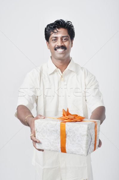 Stock photo: South Indian man giving a gift box