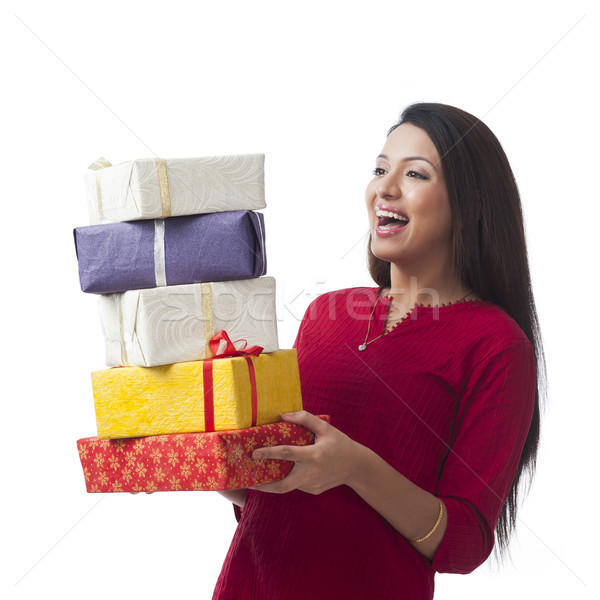 Happy woman holding stack of gifts and smiling Stock photo © imagedb