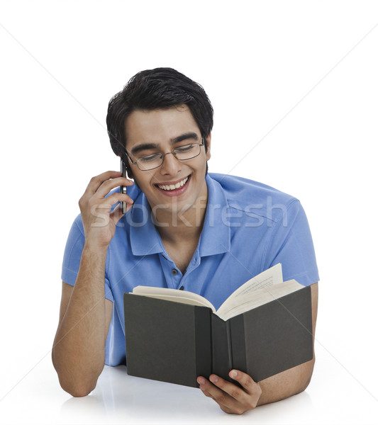 Heureux homme parler téléphone portable lecture livre [[stock_photo]] © imagedb