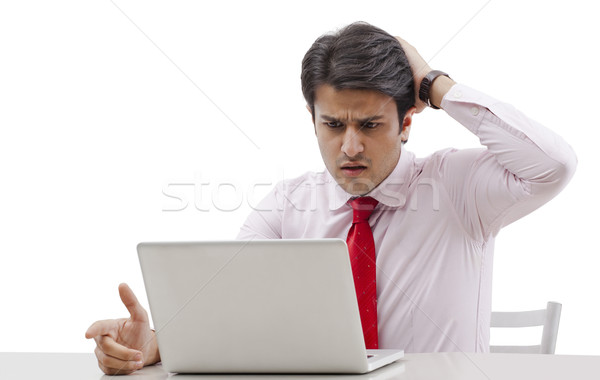 Businessman using a laptop and looking shocked Stock photo © imagedb