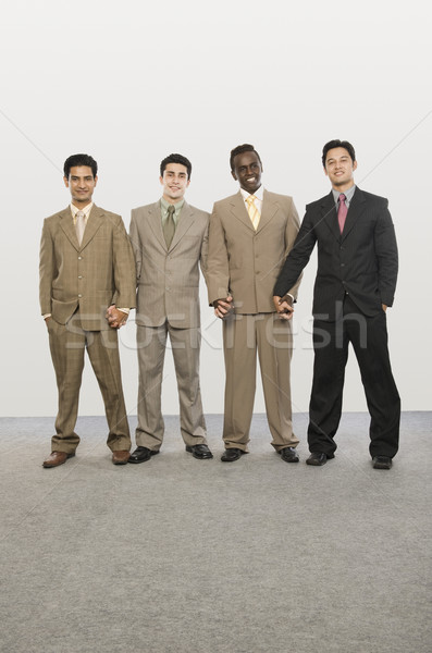 Retrato quatro empresários em pé juntos de mãos dadas Foto stock © imagedb