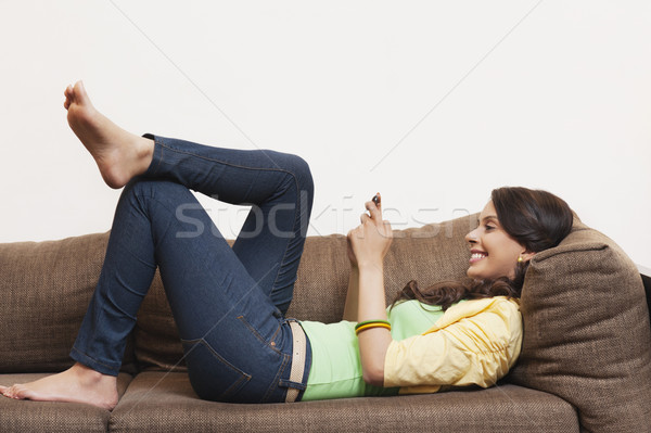 Kobieta sms telefonu komórkowego dżinsy uśmiechnięty związku Zdjęcia stock © imagedb