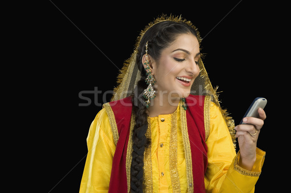 Nő hagyományos ruha néz mobiltelefon portré Stock fotó © imagedb