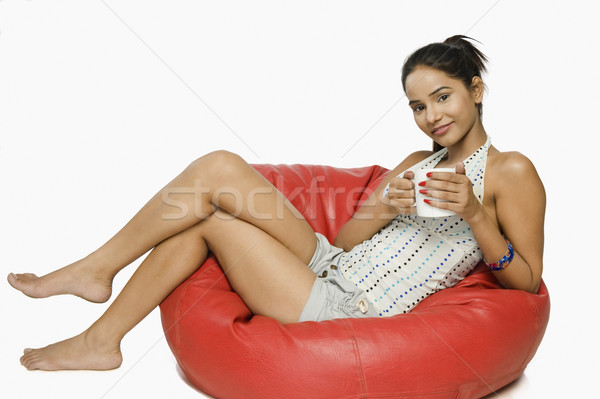Vrouw vergadering bean bag beker koffie glimlach Stockfoto © imagedb