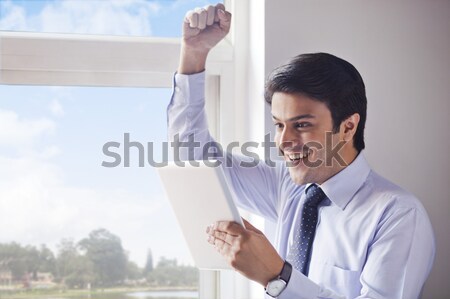 Businessman using a digital tablet and looking excited Stock photo © imagedb