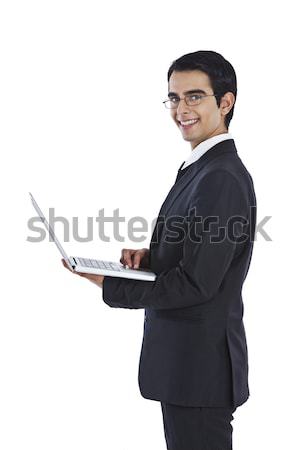 Portrait of a businessman using a laptop and showing thumbs up Stock photo © imagedb