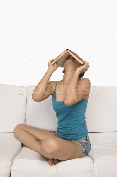 Frau Sitzung Couch Gesicht Buch jungen Stock foto © imagedb