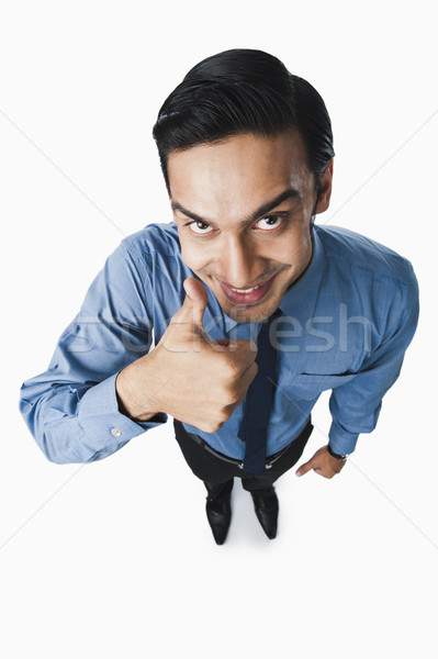 Bengali businessman showing thumbs up sign and smiling Stock photo © imagedb