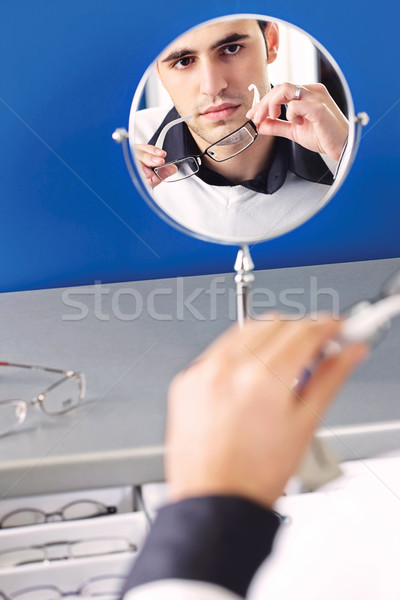 Face of a man in a mirror while he testing eyeglasses Stock photo © imarin